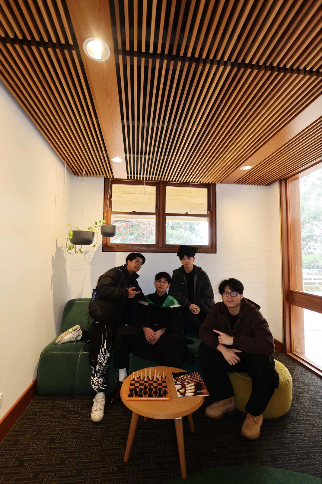 Four friends celebrating graduation together indoors
